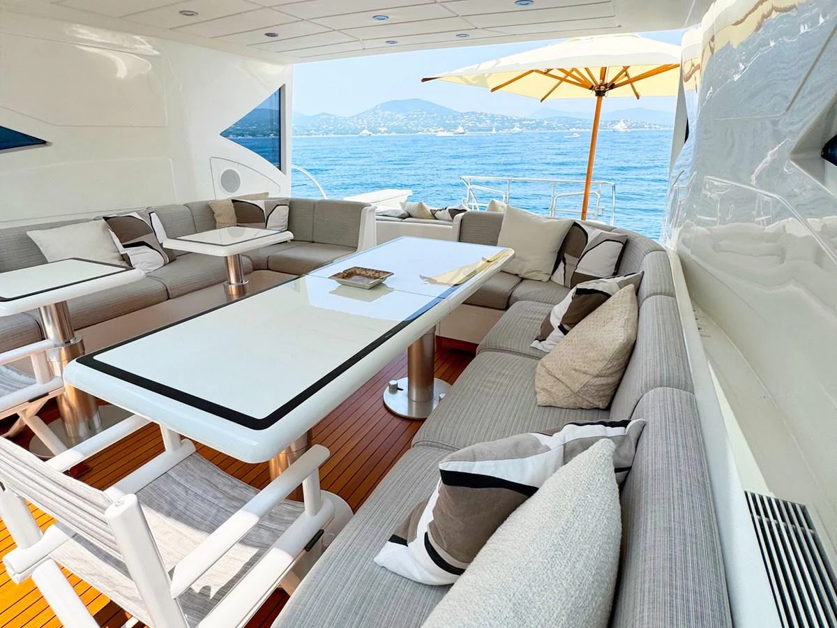 The aft deck features a spacious seating area with a large table, perfect for alfresco dining and relaxation. aboard CARO Yacht for Sale