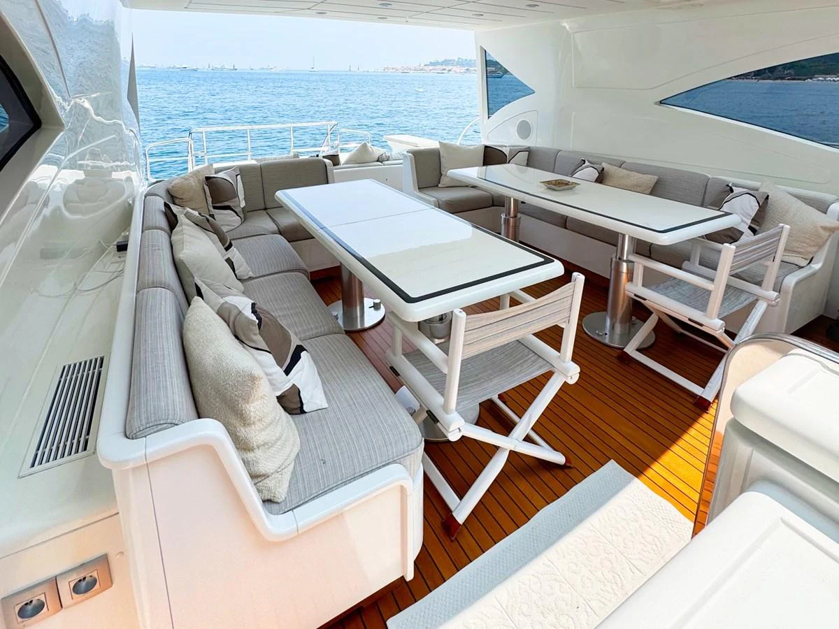 The aft deck features a spacious seating area with elegant tables and comfortable chairs, perfect for outdoor dining and relaxation. aboard CARO Yacht for Sale
