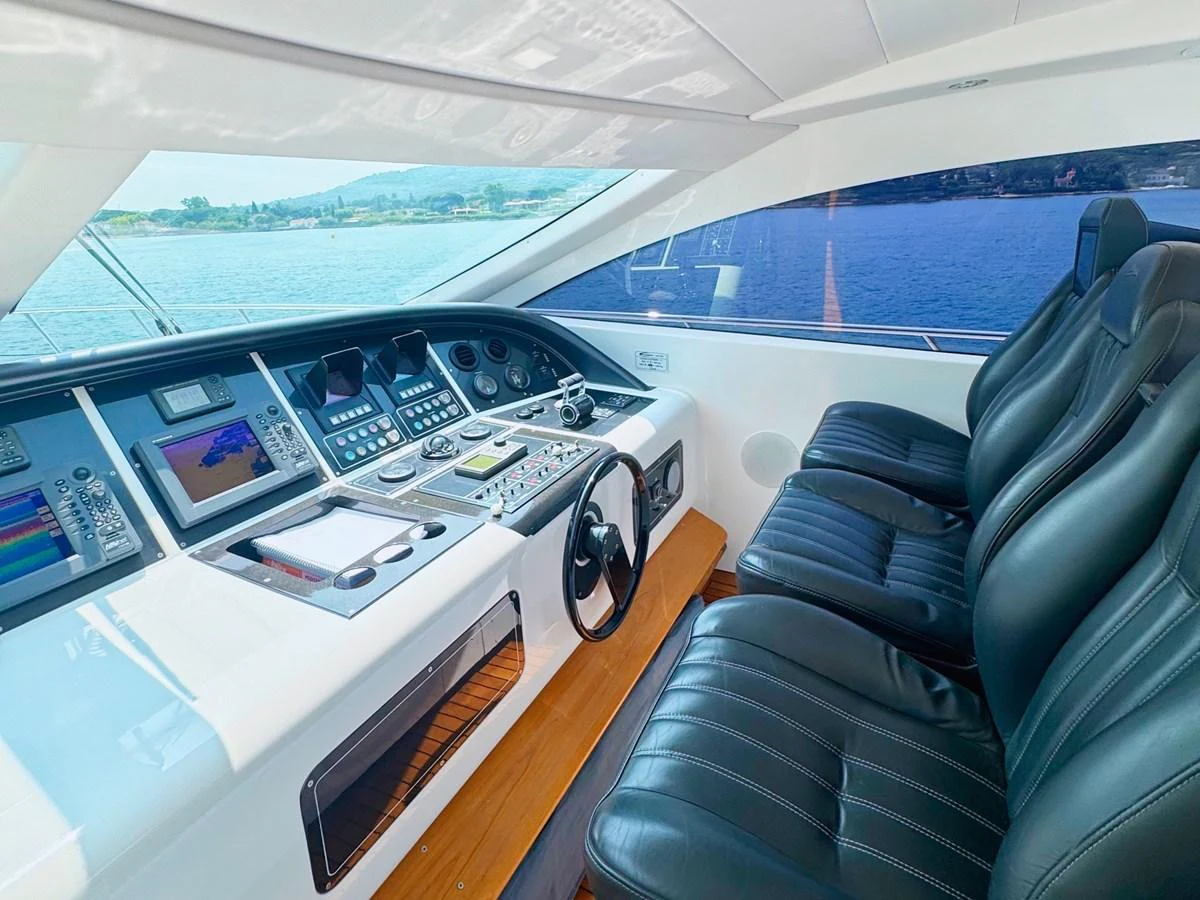 The helm station features modern navigation equipment and comfortable seating with a panoramic view of the water. aboard CARO Yacht for Sale