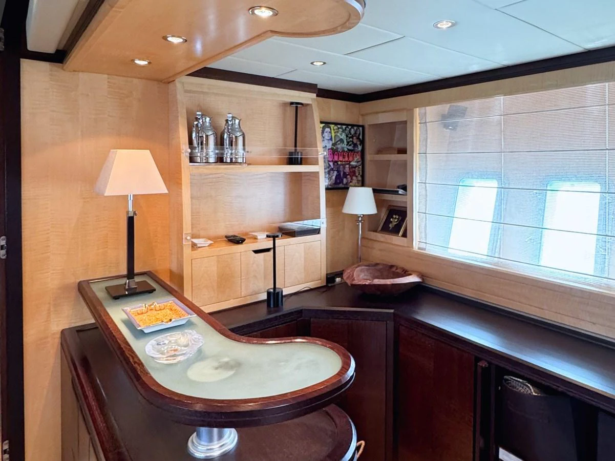 The yacht's interior features a stylish bar area with elegant wood finishes and modern lighting. aboard CARO Yacht for Sale