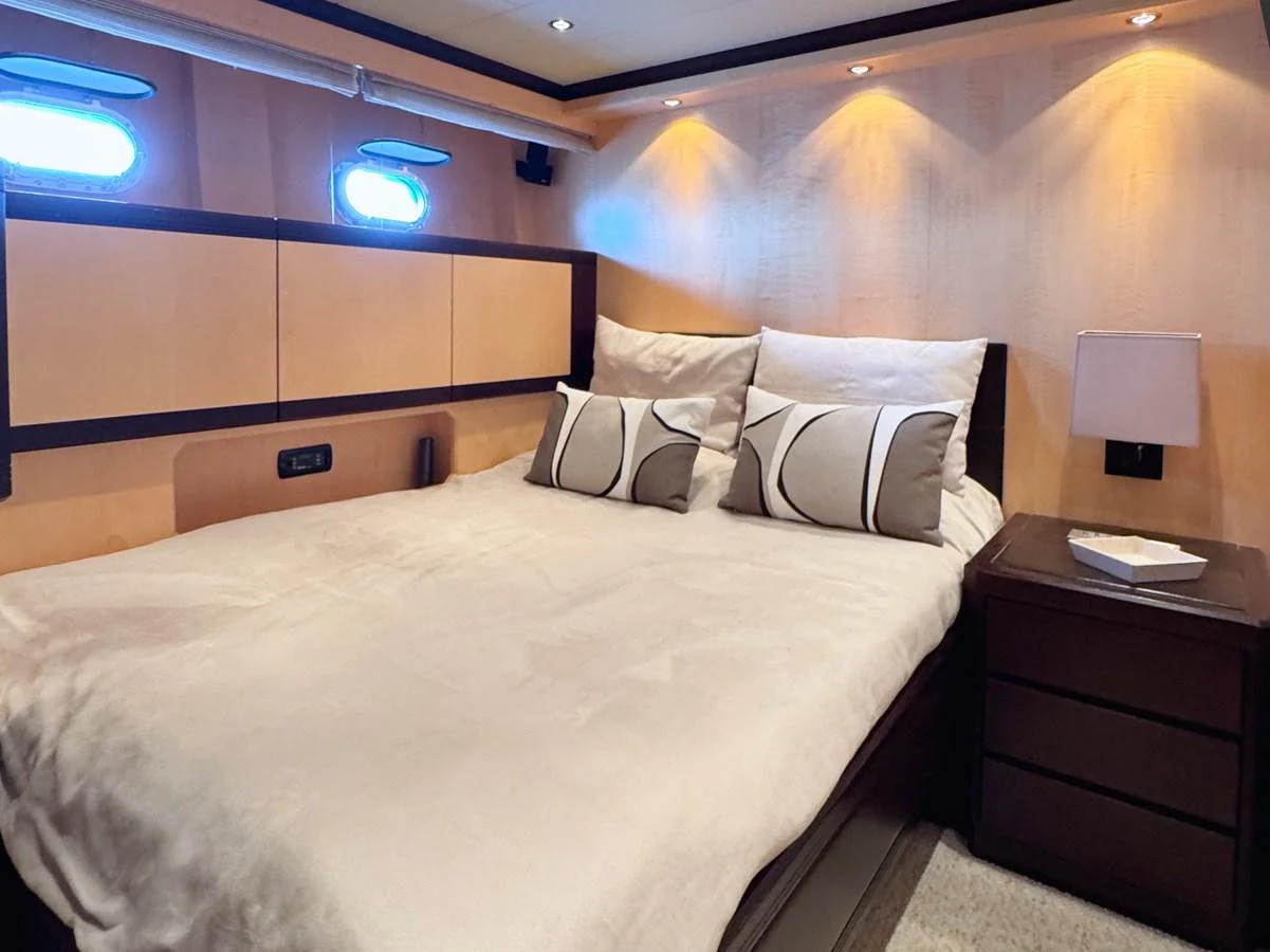 The stateroom features a cozy bed with elegant bedding and soft lighting, creating a warm and inviting atmosphere. aboard CARO Yacht for Sale