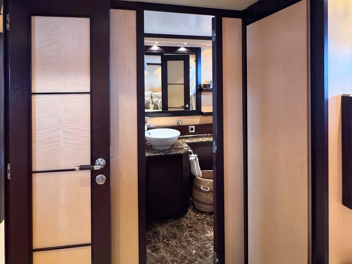 The yacht's bathroom features elegant wood finishes and a modern sink. aboard CARO Yacht for Sale