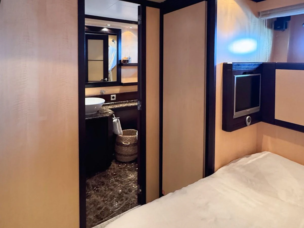 A cozy guest stateroom featuring a comfortable bed and an en-suite bathroom. aboard CARO Yacht for Sale