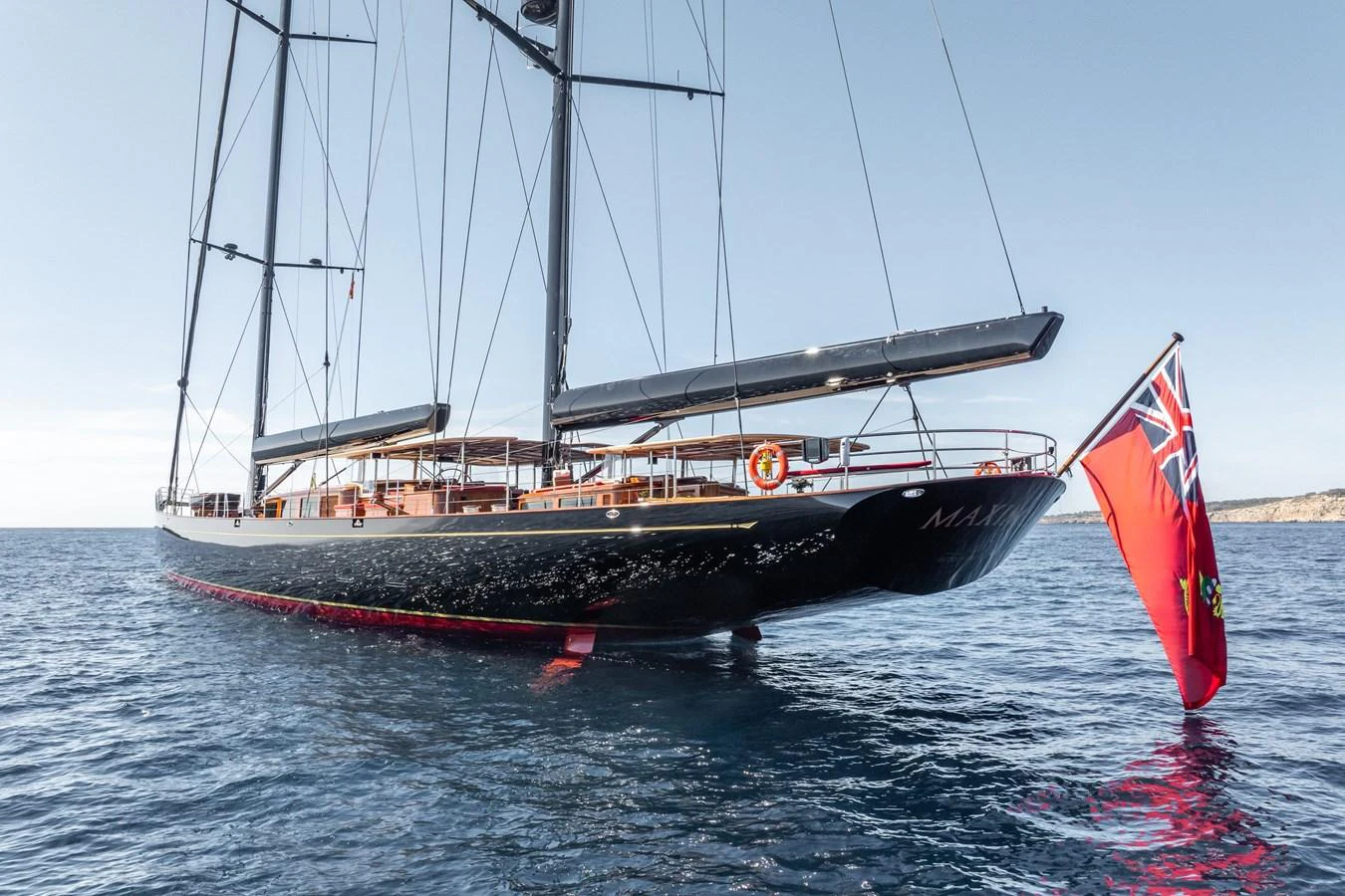 A sleek sailing yacht glides gracefully on the open water, showcasing its elegant design and impressive rigging. aboard MAXIMUS Yacht for Sale