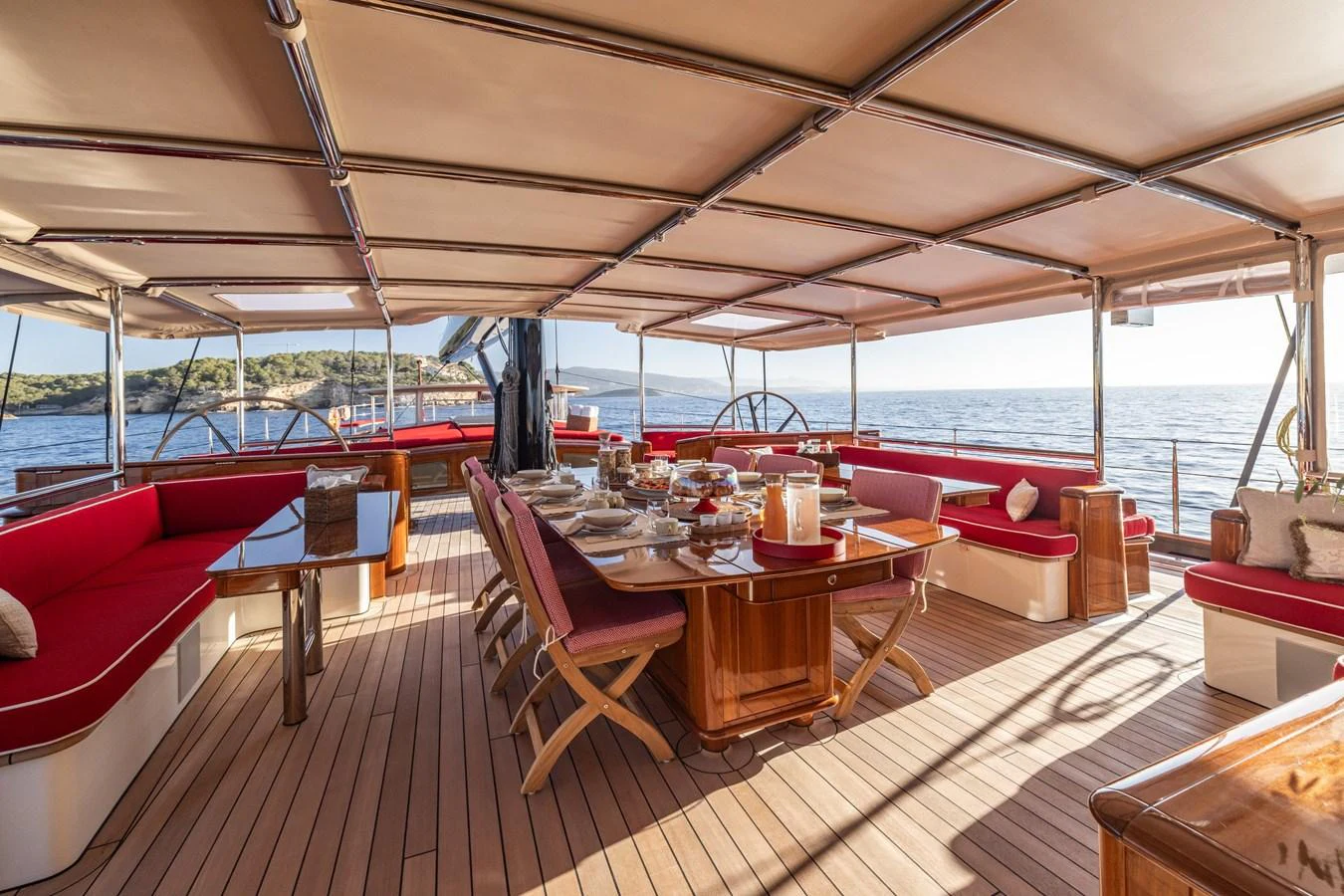 The aft deck features a spacious dining area with elegant wooden furniture and comfortable seating, perfect for alfresco dining. aboard MAXIMUS Yacht for Sale