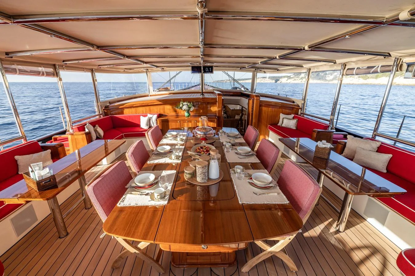 The yacht's dining area features a beautifully set table with a panoramic view of the sea. aboard MAXIMUS Yacht for Sale