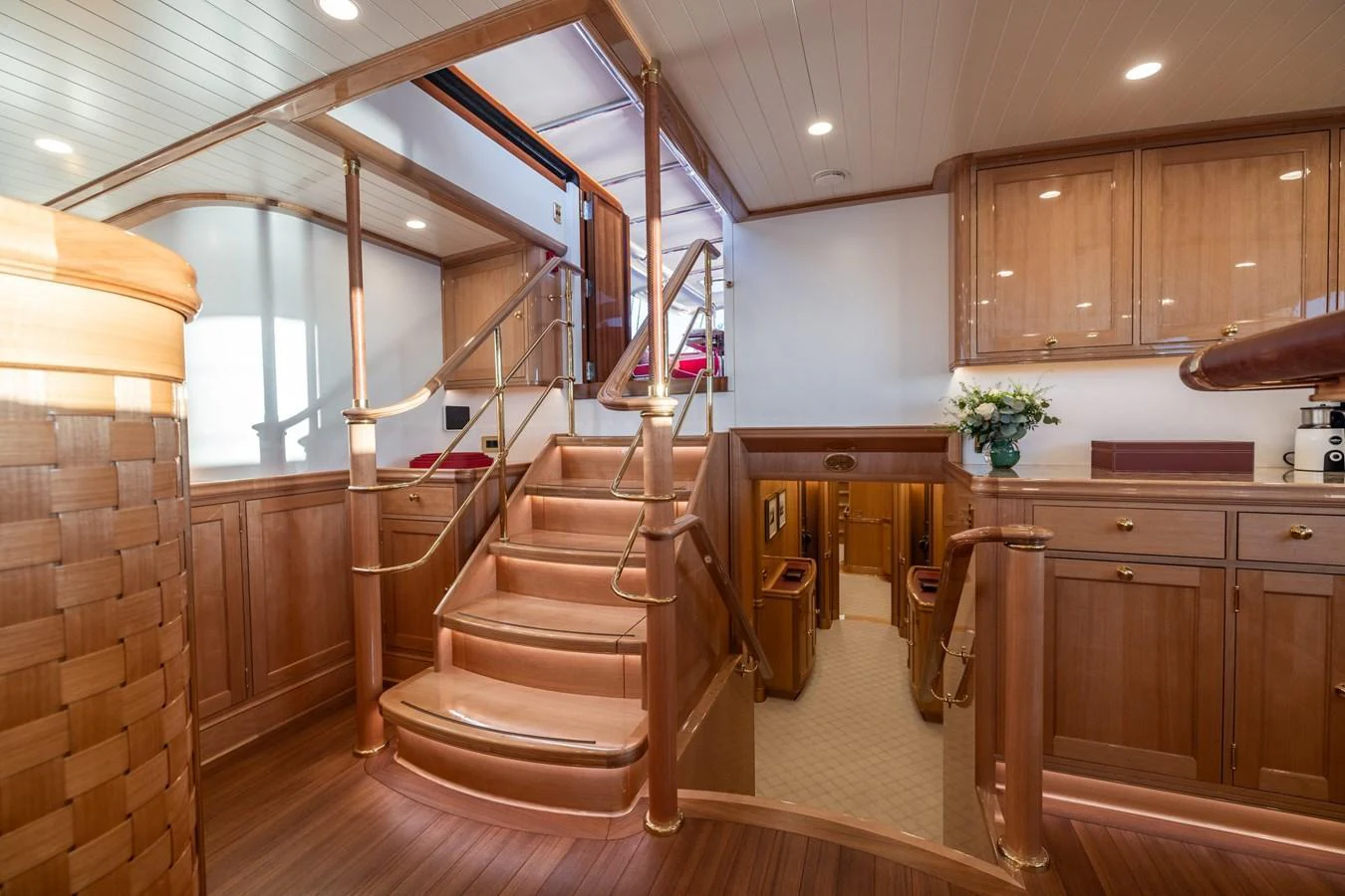 The yacht's interior features elegant wooden finishes and a stylish staircase leading to the upper deck. aboard MAXIMUS Yacht for Sale