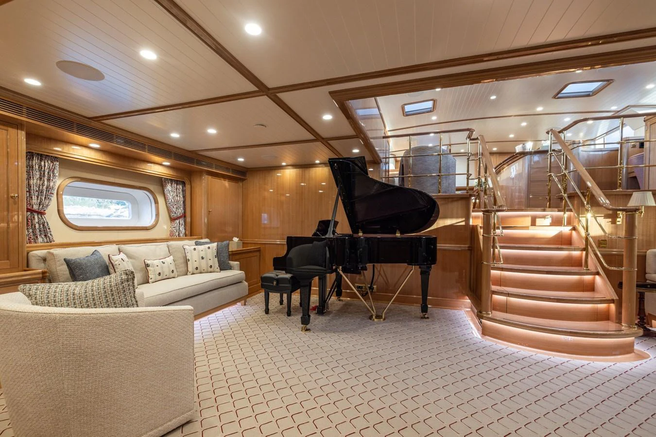 The yacht's salon features elegant wood paneling, a grand piano, and a comfortable seating area. aboard MAXIMUS Yacht for Sale