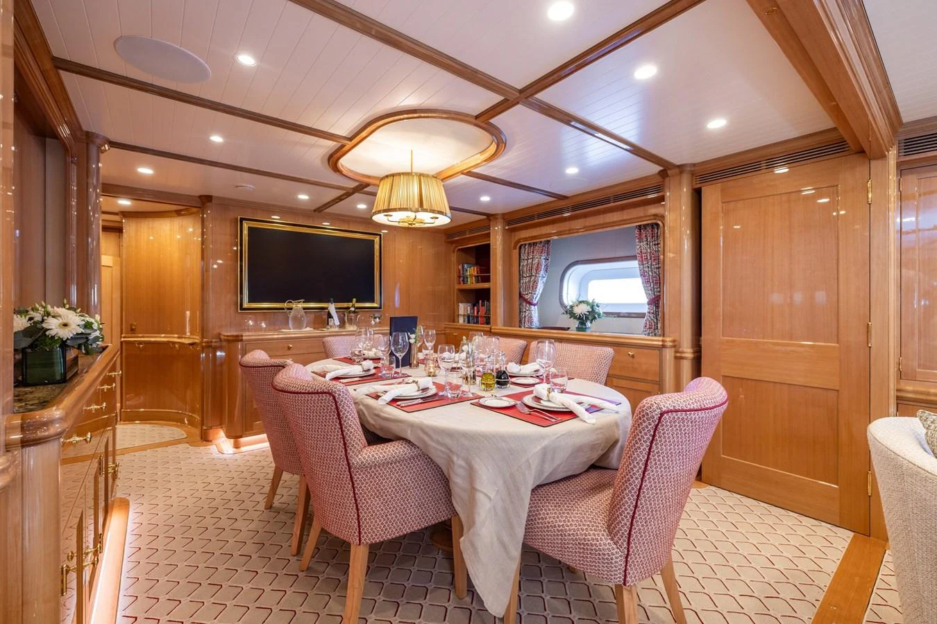 The yacht's dining area exudes elegance with its finely set table and warm wooden accents. aboard MAXIMUS Yacht for Sale