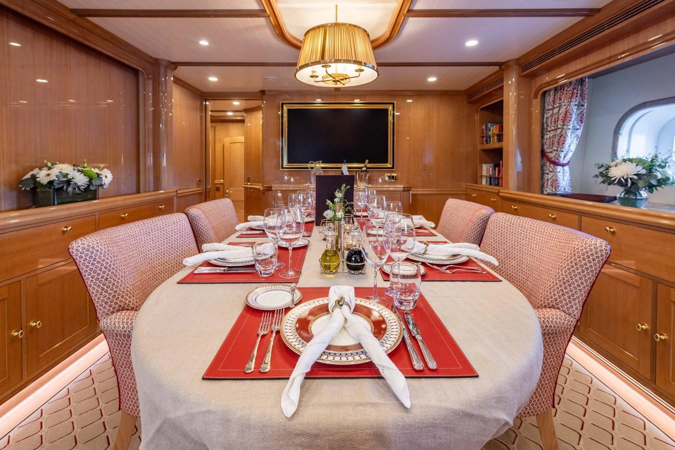 The yacht's dining area features an elegant table setting with luxurious decor and ambient lighting. aboard MAXIMUS Yacht for Sale