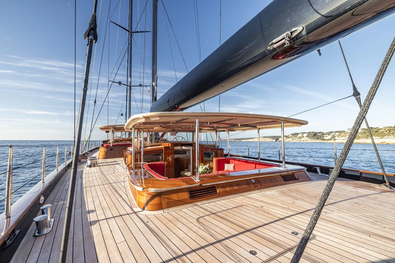 The yacht's deck features elegant wooden finishes and comfortable seating areas under a shaded canopy. aboard MAXIMUS Yacht for Sale