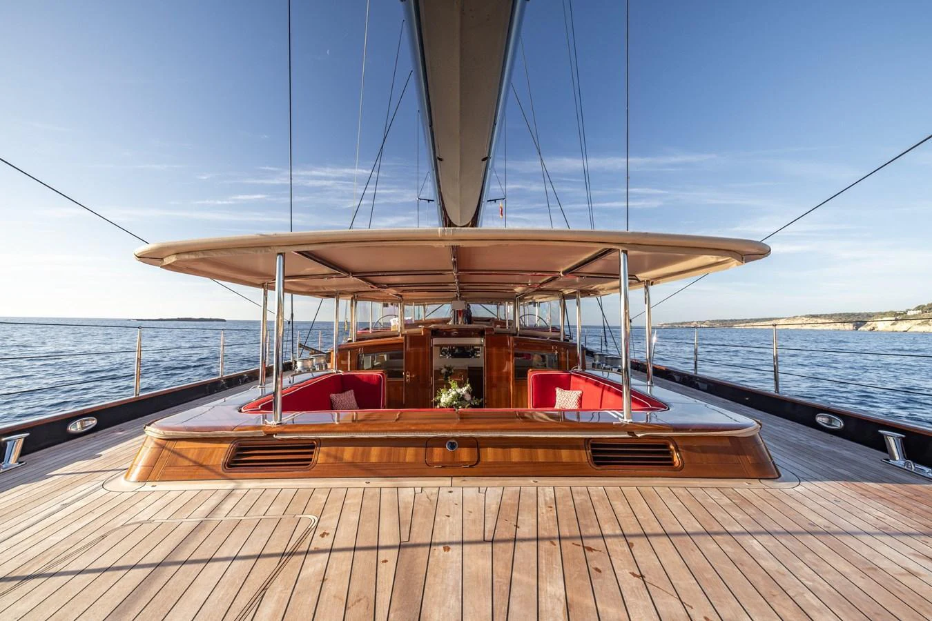 The yacht's deck features elegant wooden finishes and comfortable seating areas under a large canopy. aboard MAXIMUS Yacht for Sale