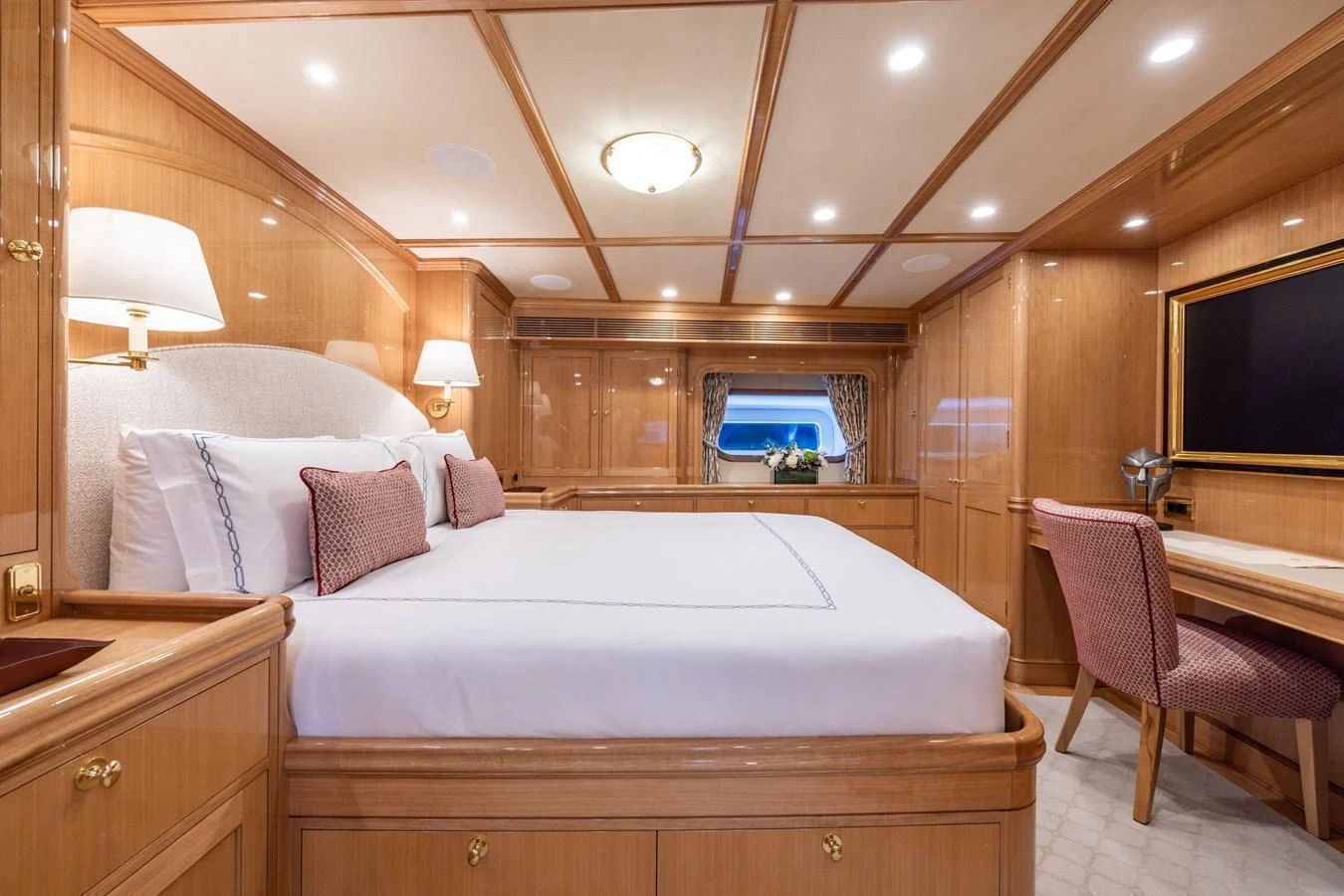 The master stateroom features a spacious bed, elegant wood paneling, and a cozy seating area. aboard MAXIMUS Yacht for Sale