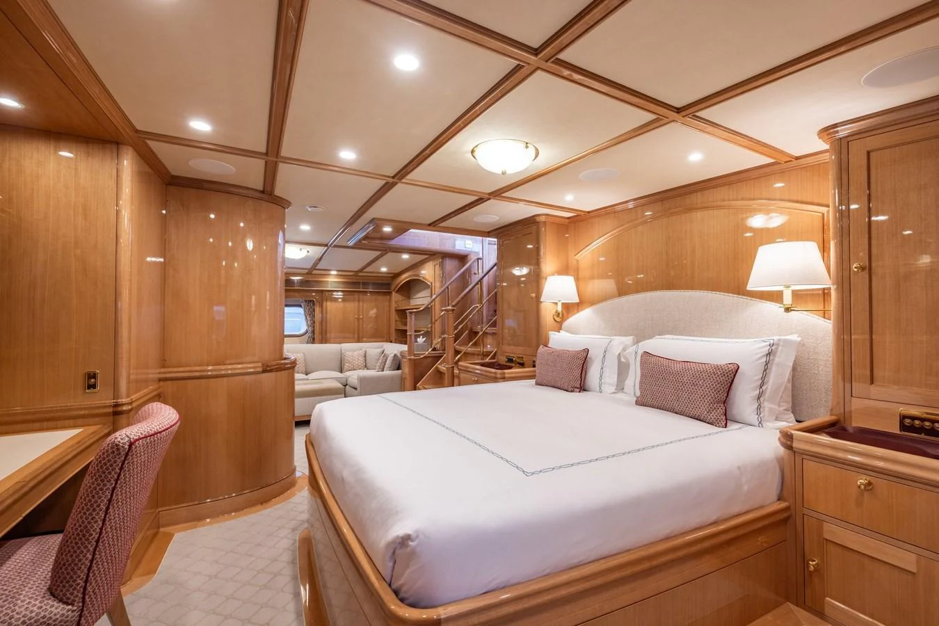 The master stateroom features a luxurious bed, elegant wood paneling, and ample lighting. aboard MAXIMUS Yacht for Sale