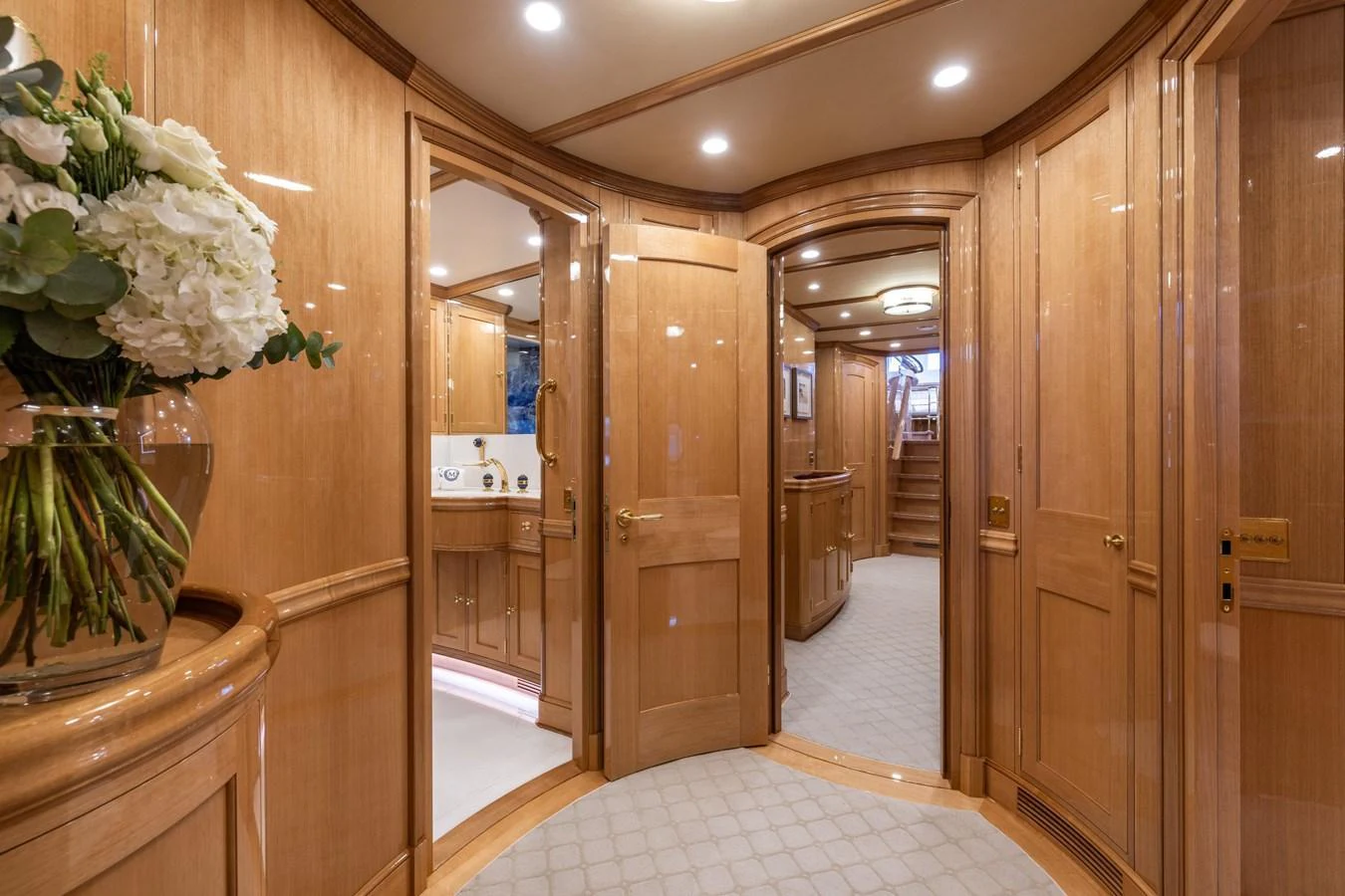 The yacht's interior features a luxurious hallway with polished wood paneling and elegant lighting. aboard MAXIMUS Yacht for Sale