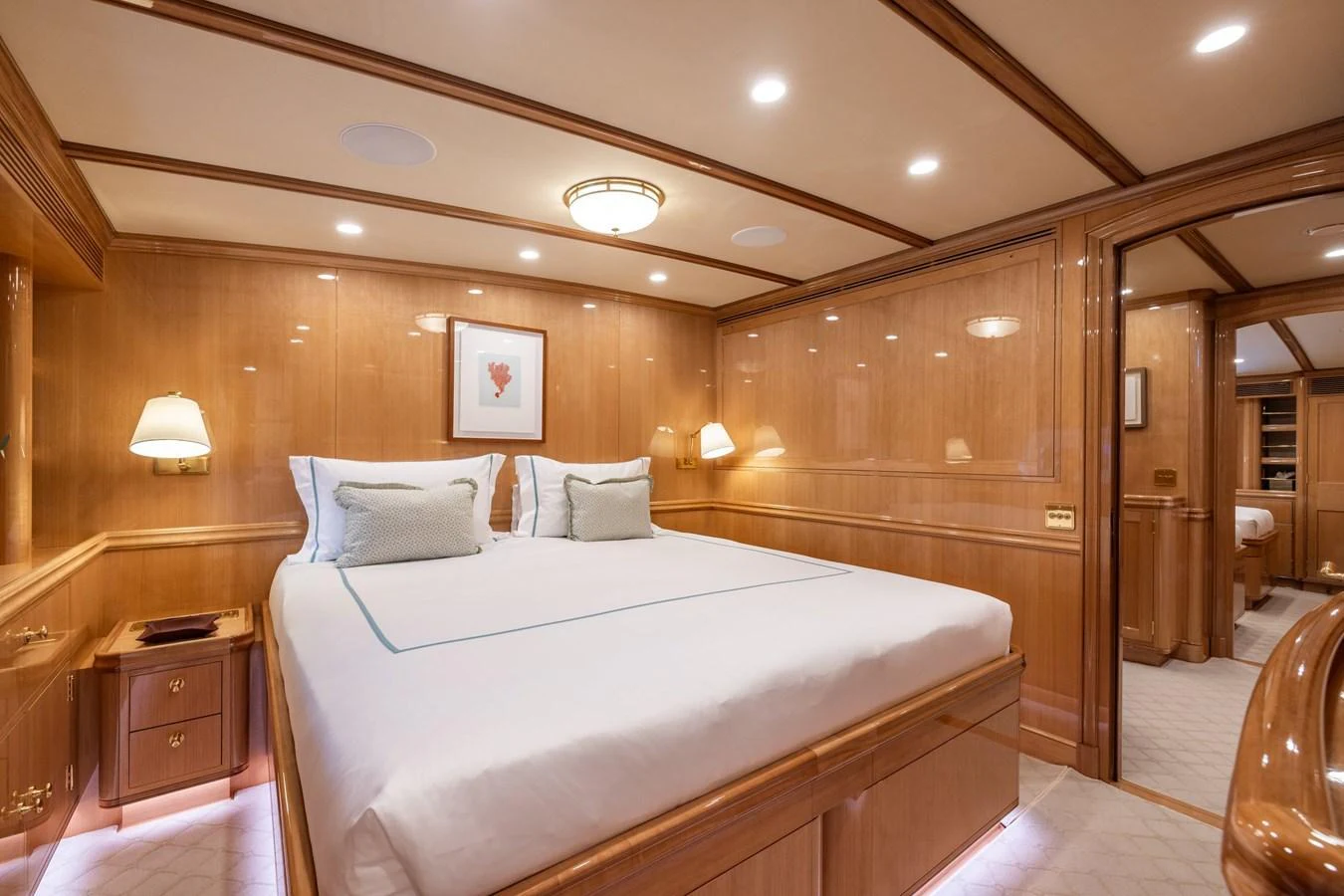 The stateroom features a luxurious bed with elegant wood paneling and soft lighting. aboard MAXIMUS Yacht for Sale