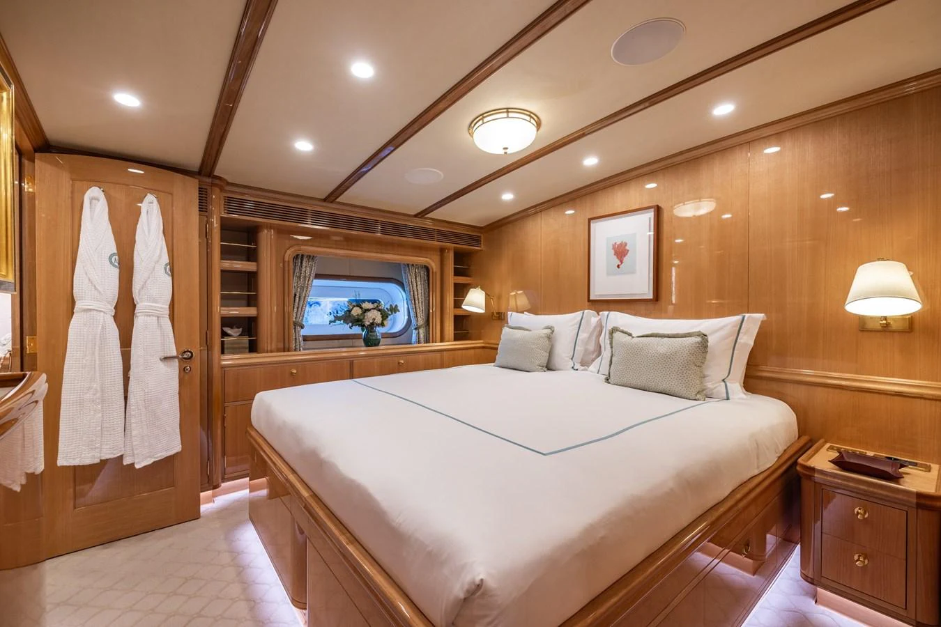 The stateroom features a luxurious bed with elegant wood paneling and soft lighting. aboard MAXIMUS Yacht for Sale