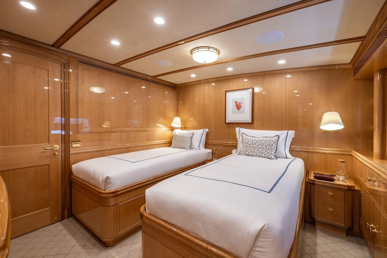 The twin stateroom features elegant wood paneling and plush bedding for a comfortable stay. aboard MAXIMUS Yacht for Sale