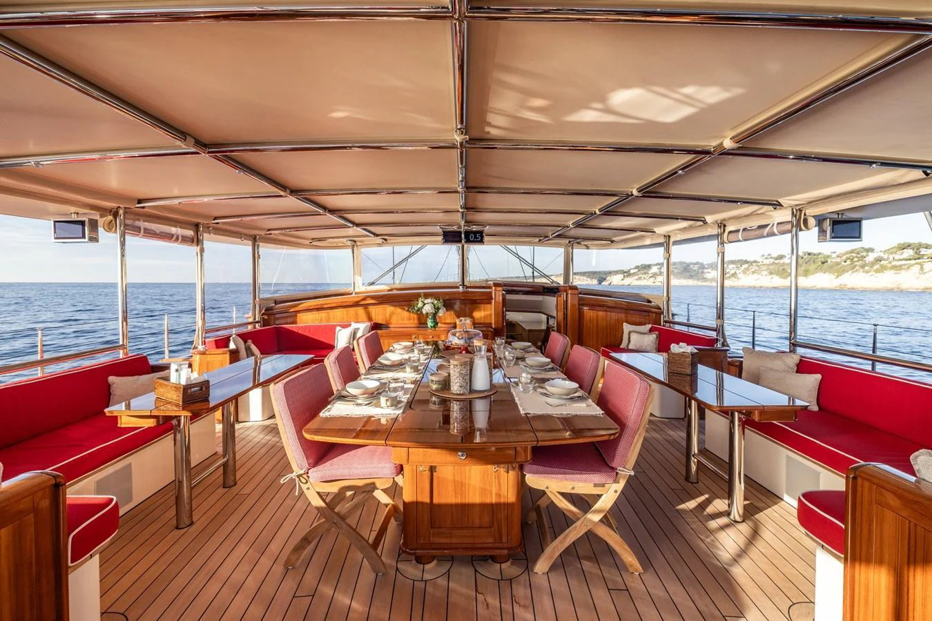 The yacht's dining area features a spacious and elegant setup with a beautifully set table and comfortable seating, perfect for enjoying meals with a view of the sea. aboard MAXIMUS Yacht for Sale