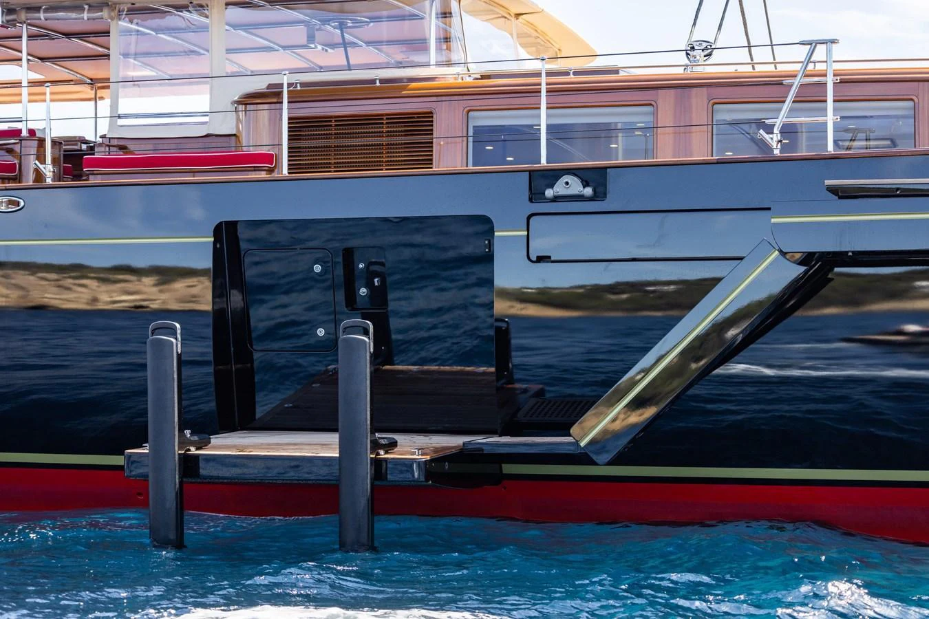 A close-up view of the yacht's side boarding platform and hull details. aboard MAXIMUS Yacht for Sale