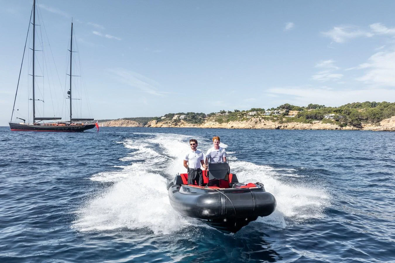 A sleek tender speeds across the water with two people on board, leaving a trail of white foam behind. aboard MAXIMUS Yacht for Sale