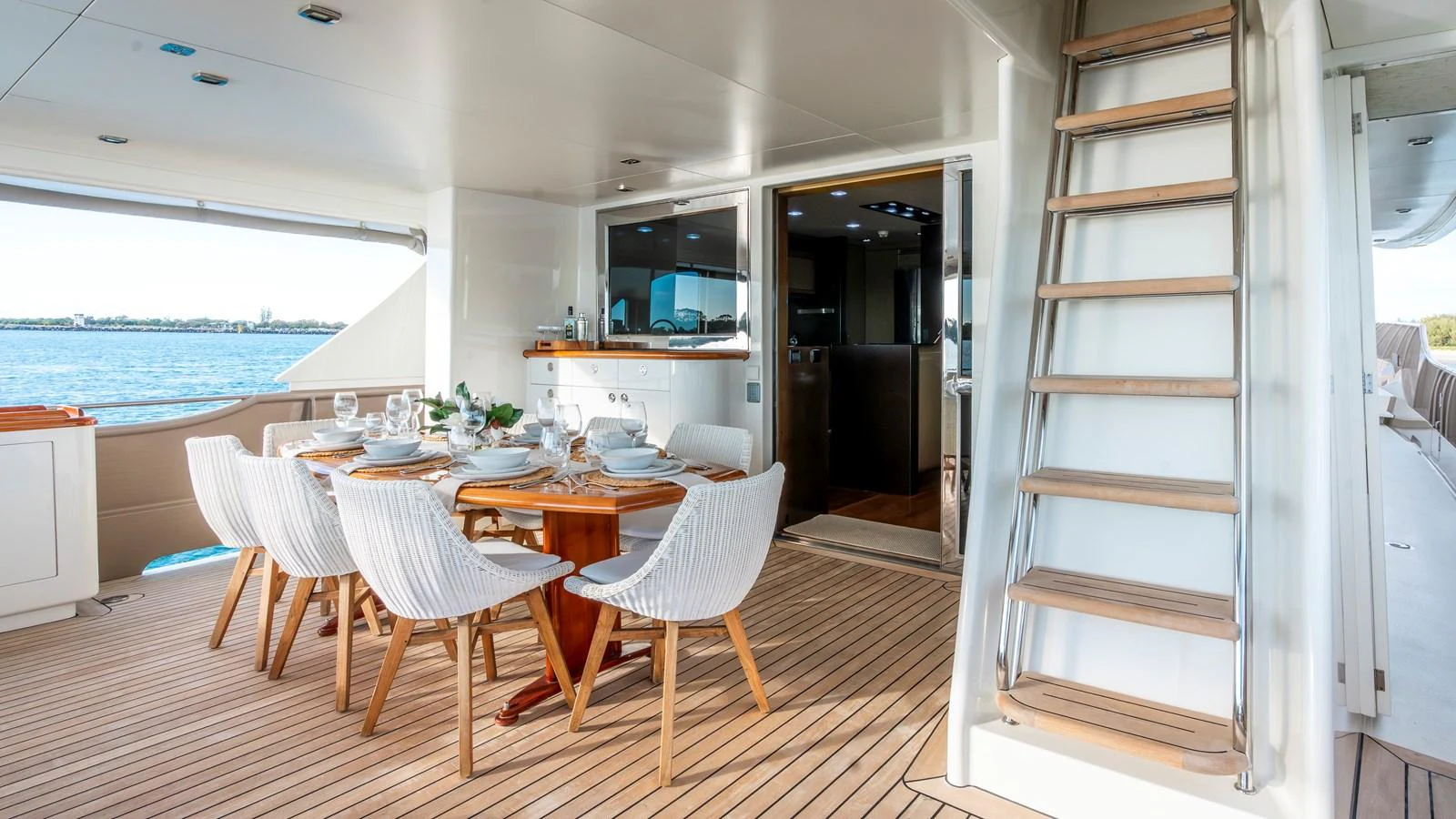 The aft deck features an elegant dining area with a view of the water. aboard TEXAS T Yacht for Sale