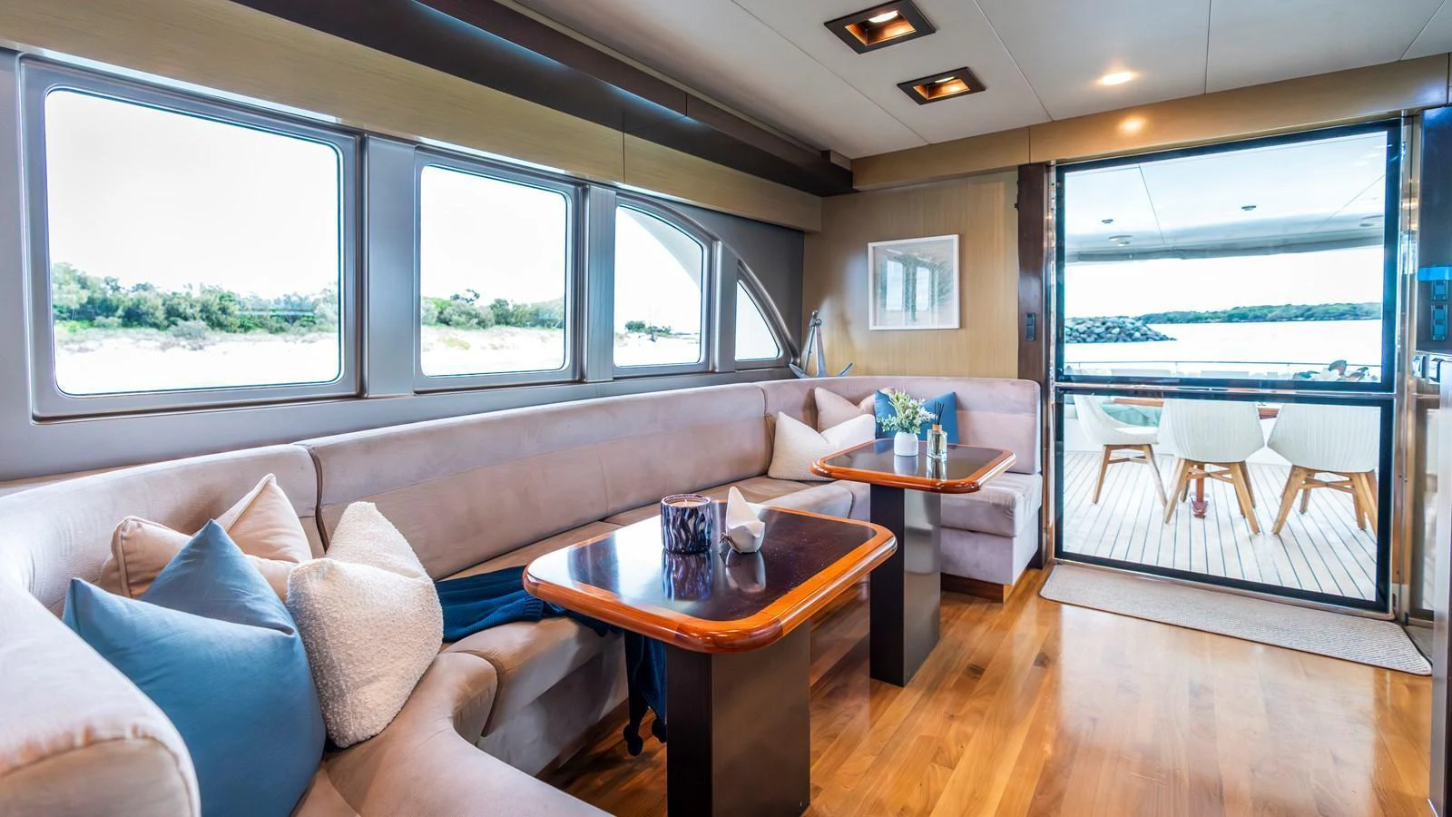 The yacht's salon features plush seating, elegant wooden tables, and large windows offering scenic views. aboard TEXAS T Yacht for Sale