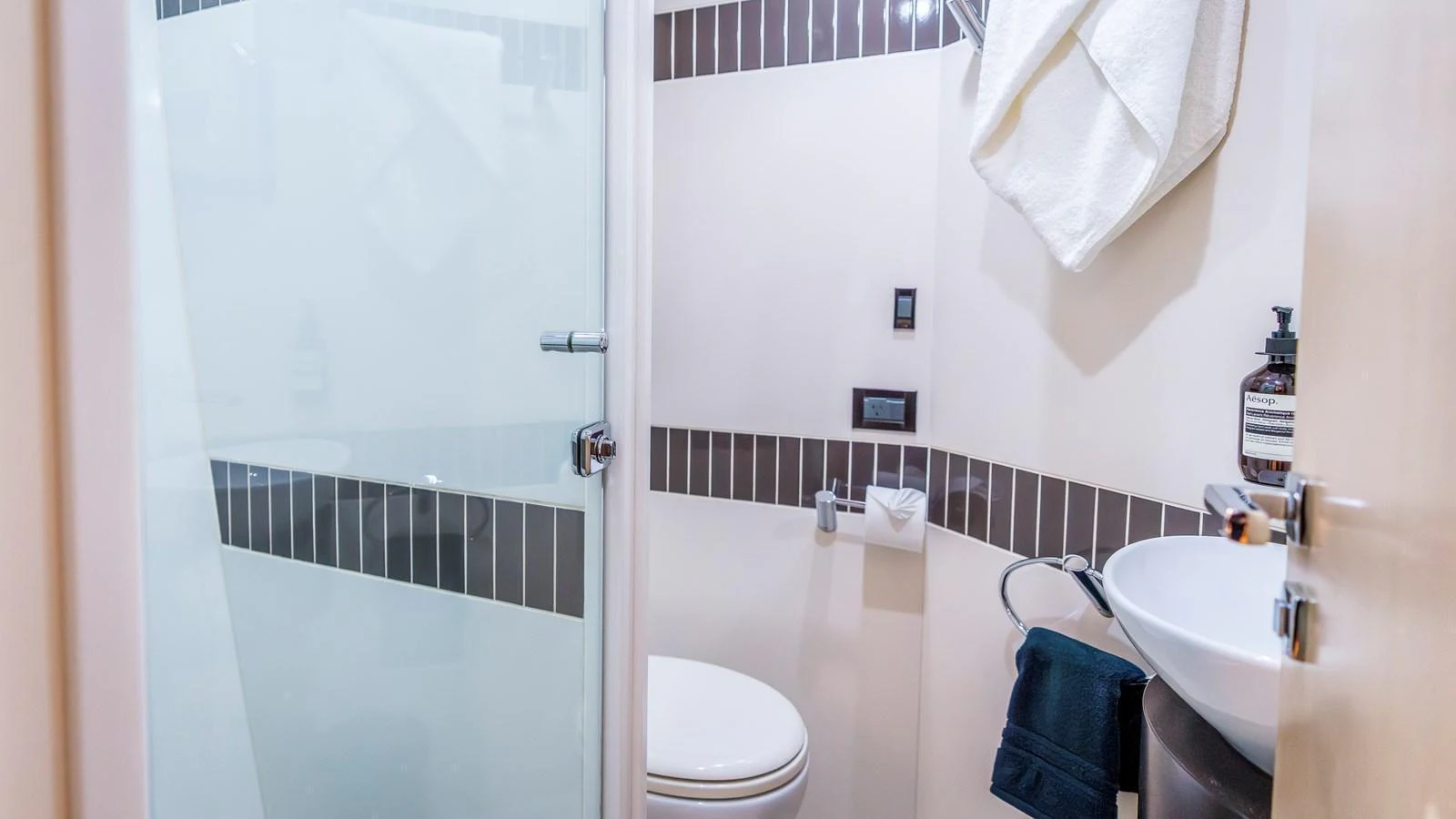 A modern yacht bathroom with sleek fixtures and a glass shower door. aboard TEXAS T Yacht for Sale