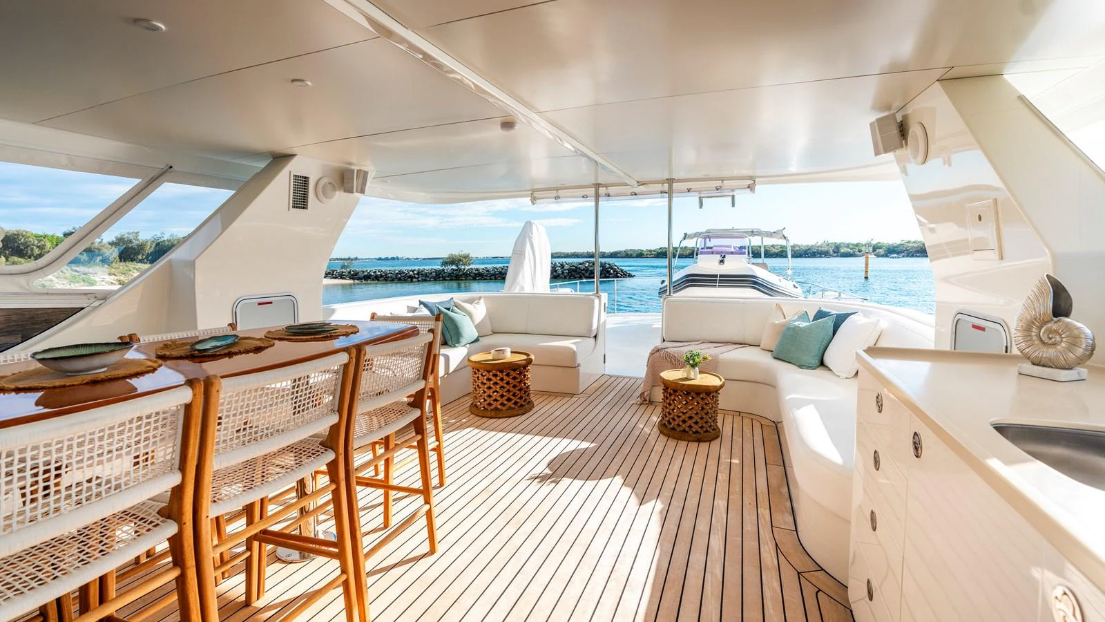 The aft deck features a spacious and elegant seating area with a dining table, perfect for alfresco dining and relaxation. aboard TEXAS T Yacht for Sale