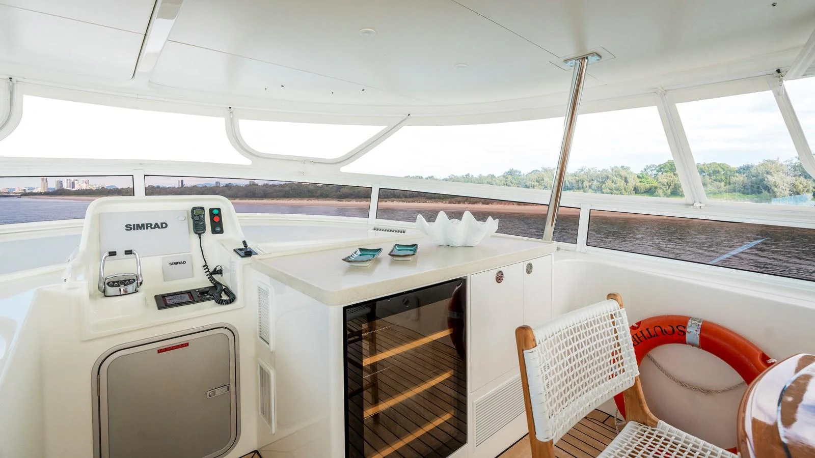The helm area features a modern control station and a small bar with a wine cooler, offering a blend of functionality and leisure. aboard TEXAS T Yacht for Sale