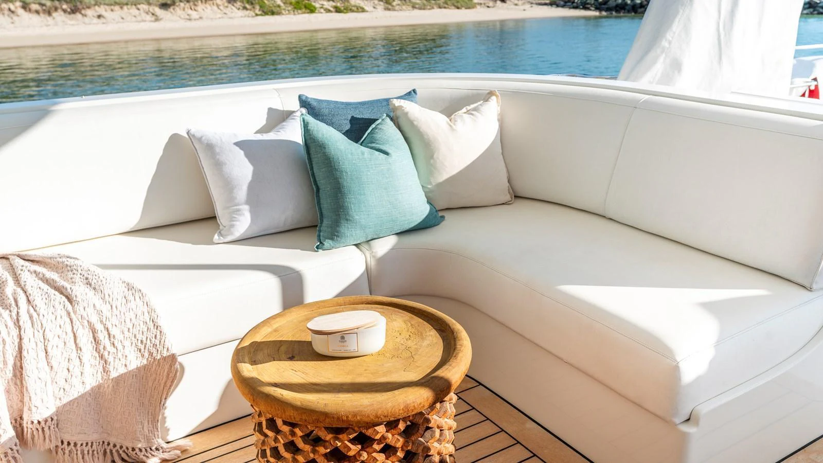 A cozy outdoor seating area with plush cushions and a small wooden table on the yacht's deck. aboard TEXAS T Yacht for Sale