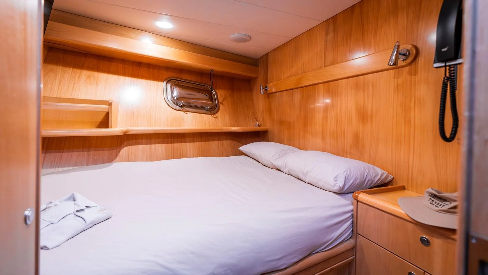 A cozy cabin with a comfortable bed and wooden paneling. aboard TEXAS T Yacht for Sale
