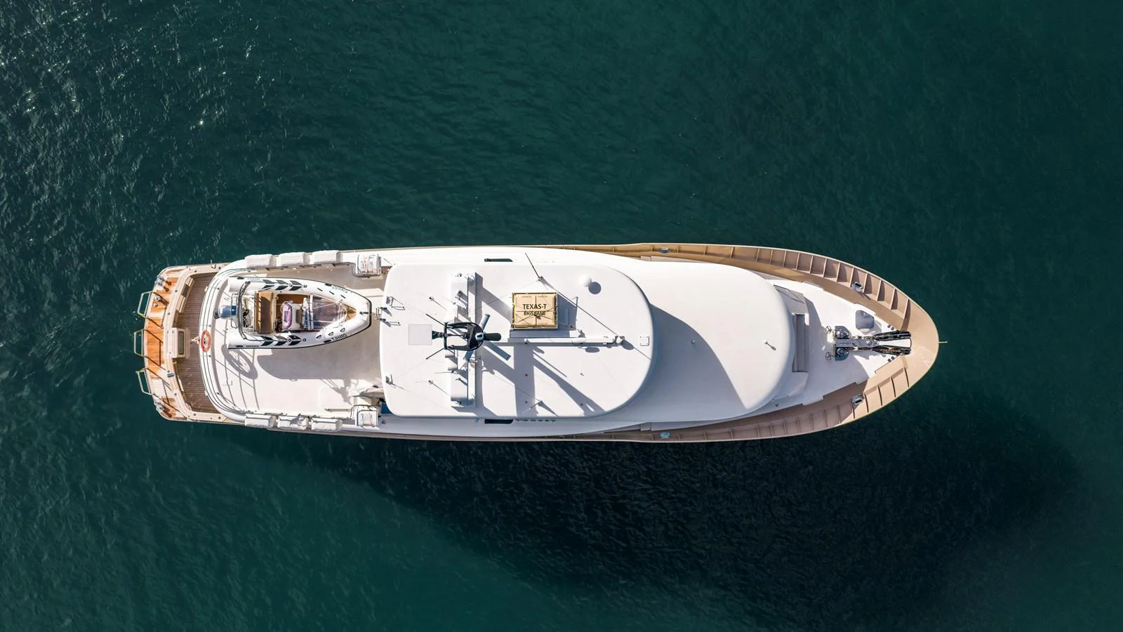 An elegant yacht is captured from above, showcasing its sleek design and spacious deck areas. aboard TEXAS T Yacht for Sale