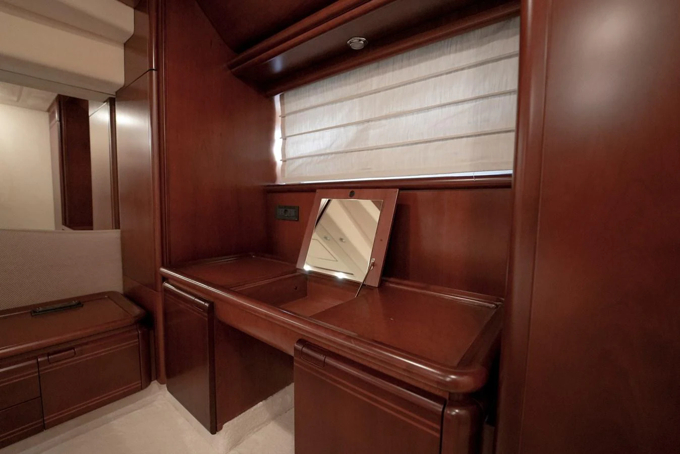 A luxurious vanity area with rich wooden cabinetry and a mirror, perfect for personal grooming. aboard HANAN Yacht for Sale