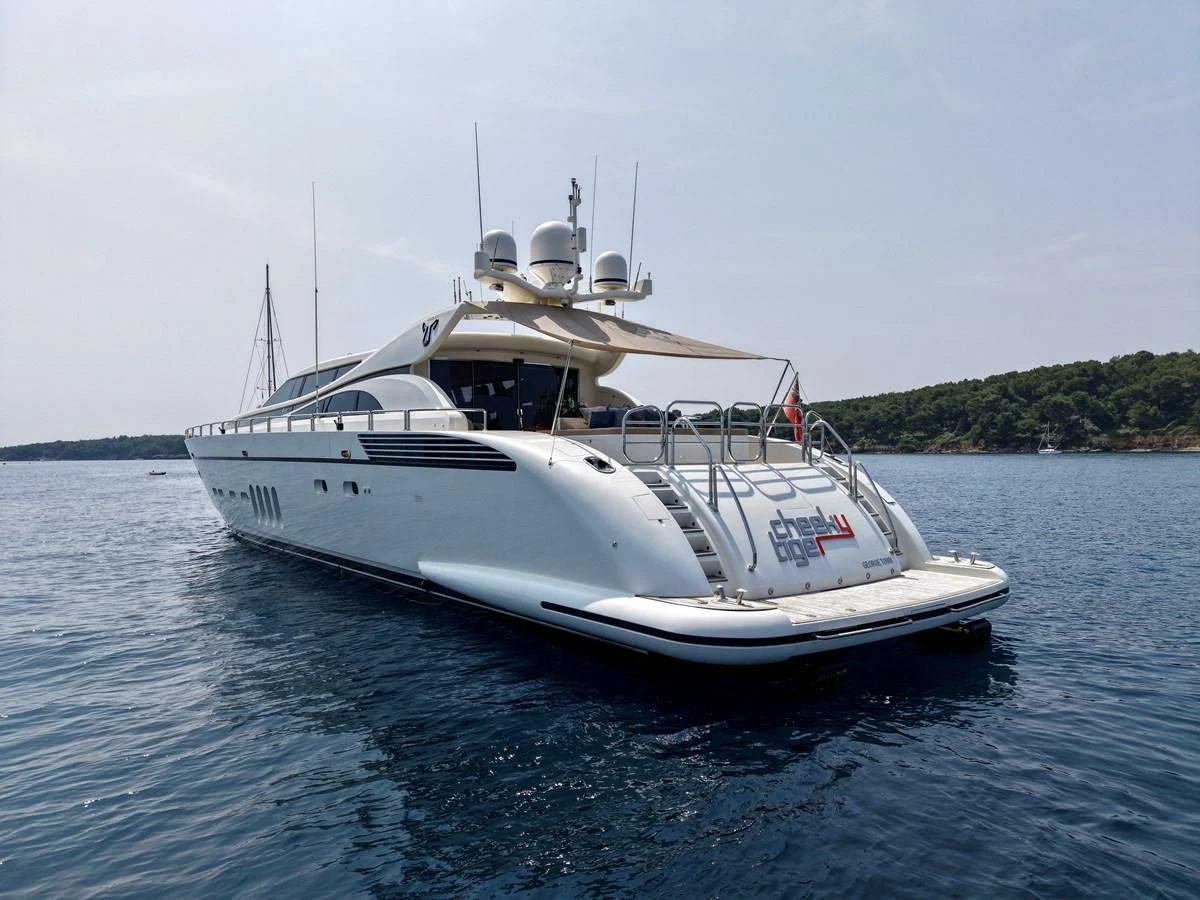 A sleek and modern yacht is anchored in calm waters, showcasing its elegant design and spacious deck. aboard CHEEKY TIGER Yacht for Sale