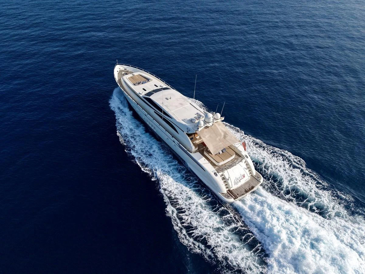 A sleek yacht cruises through the open sea, leaving a trail of white wake behind. aboard CHEEKY TIGER Yacht for Sale
