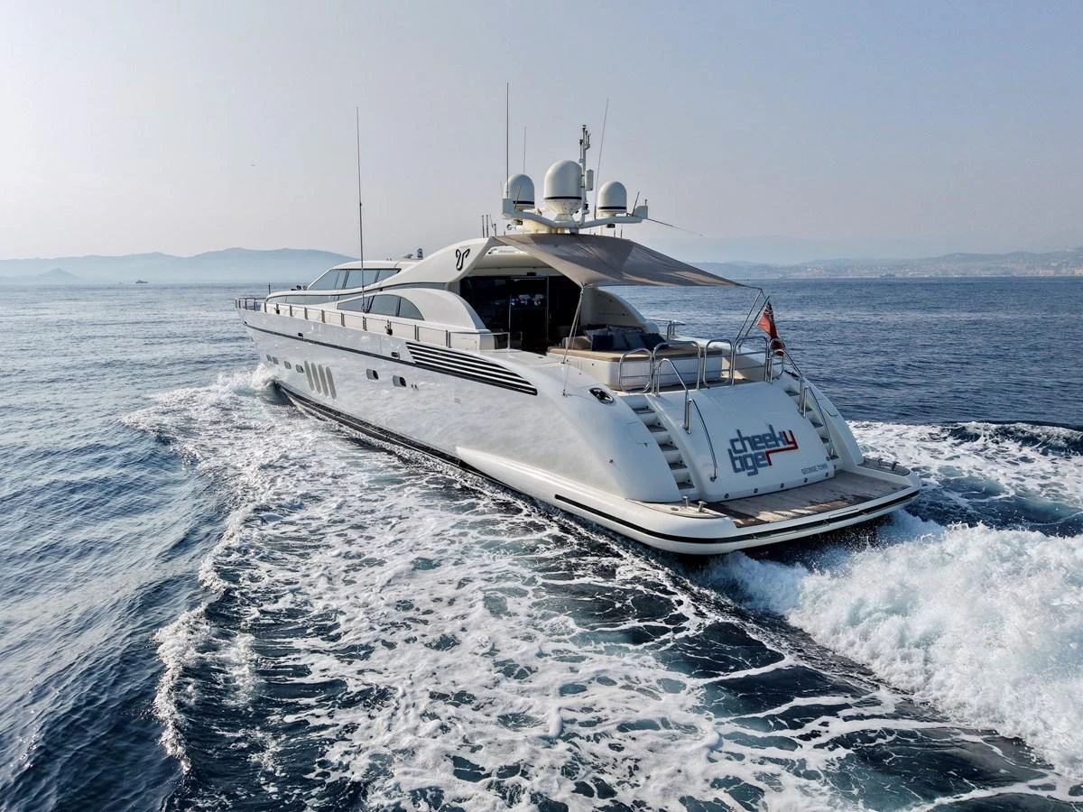 A sleek and modern yacht cruises through the open water, leaving a trail of white waves behind. aboard CHEEKY TIGER Yacht for Sale