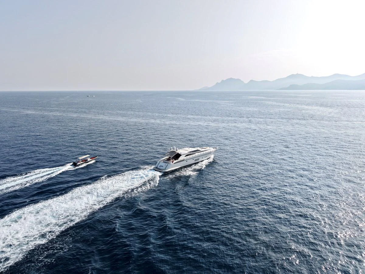 A sleek yacht cruises through open waters with a tender following closely behind. aboard CHEEKY TIGER Yacht for Sale