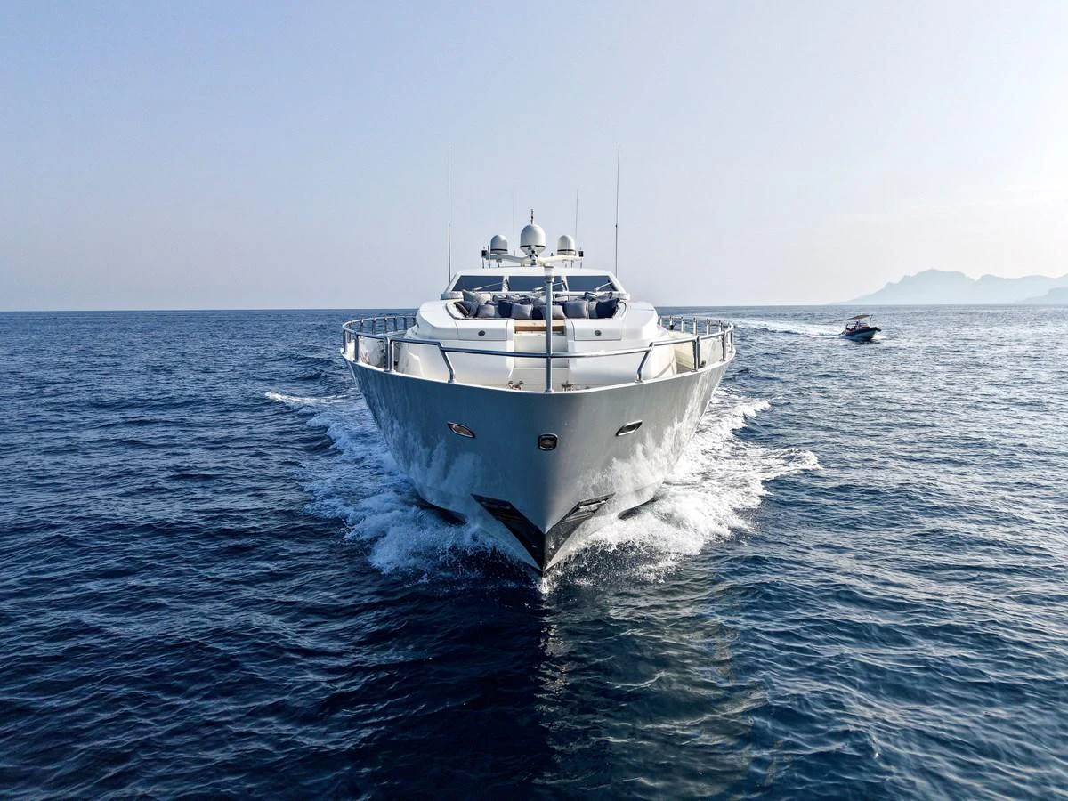A sleek yacht cruises forward on calm blue waters, showcasing its impressive bow and modern design. aboard CHEEKY TIGER Yacht for Sale
