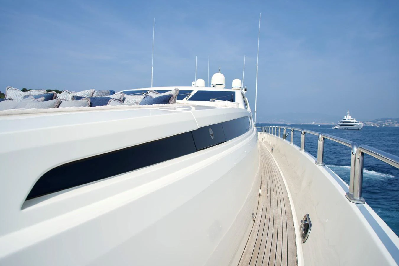 A sleek yacht cruising on calm waters with a clear blue sky overhead. aboard CHEEKY TIGER Yacht for Sale