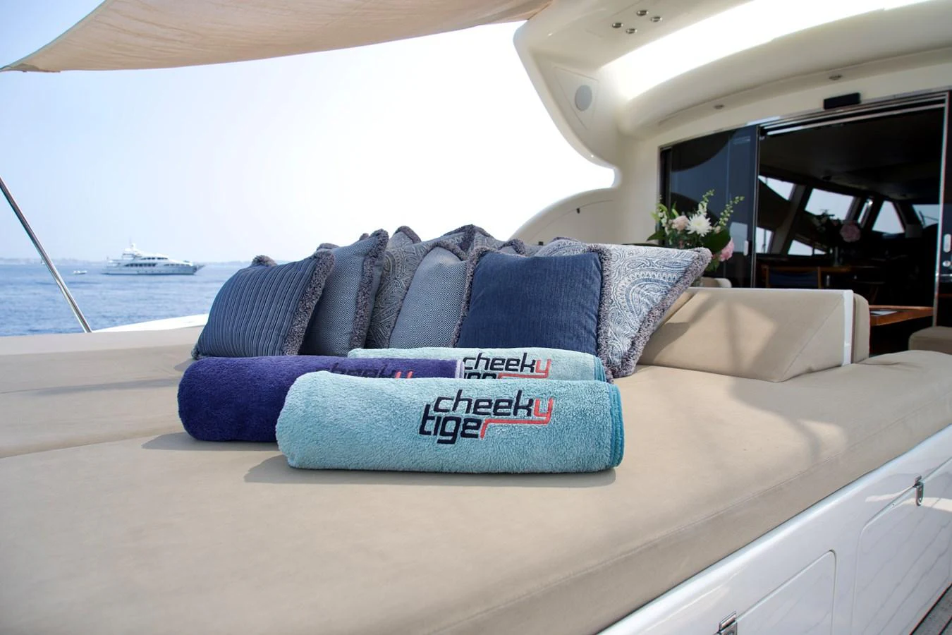 The sundeck features a comfortable lounging area with plush cushions and branded towels, perfect for relaxation. aboard CHEEKY TIGER Yacht for Sale