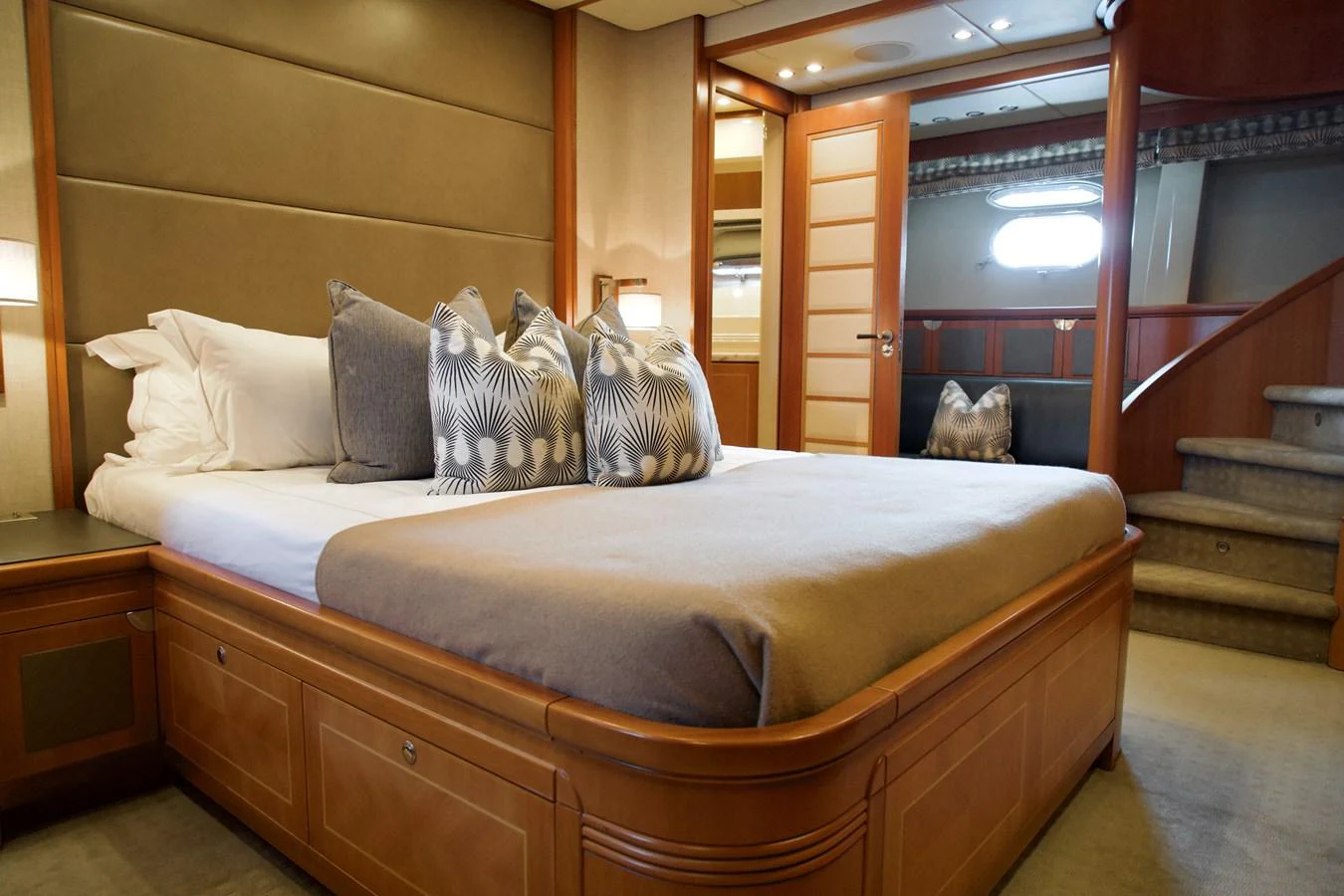 The stateroom features a plush bed with elegant pillows and warm wood accents, creating a cozy and inviting atmosphere. aboard CHEEKY TIGER Yacht for Sale
