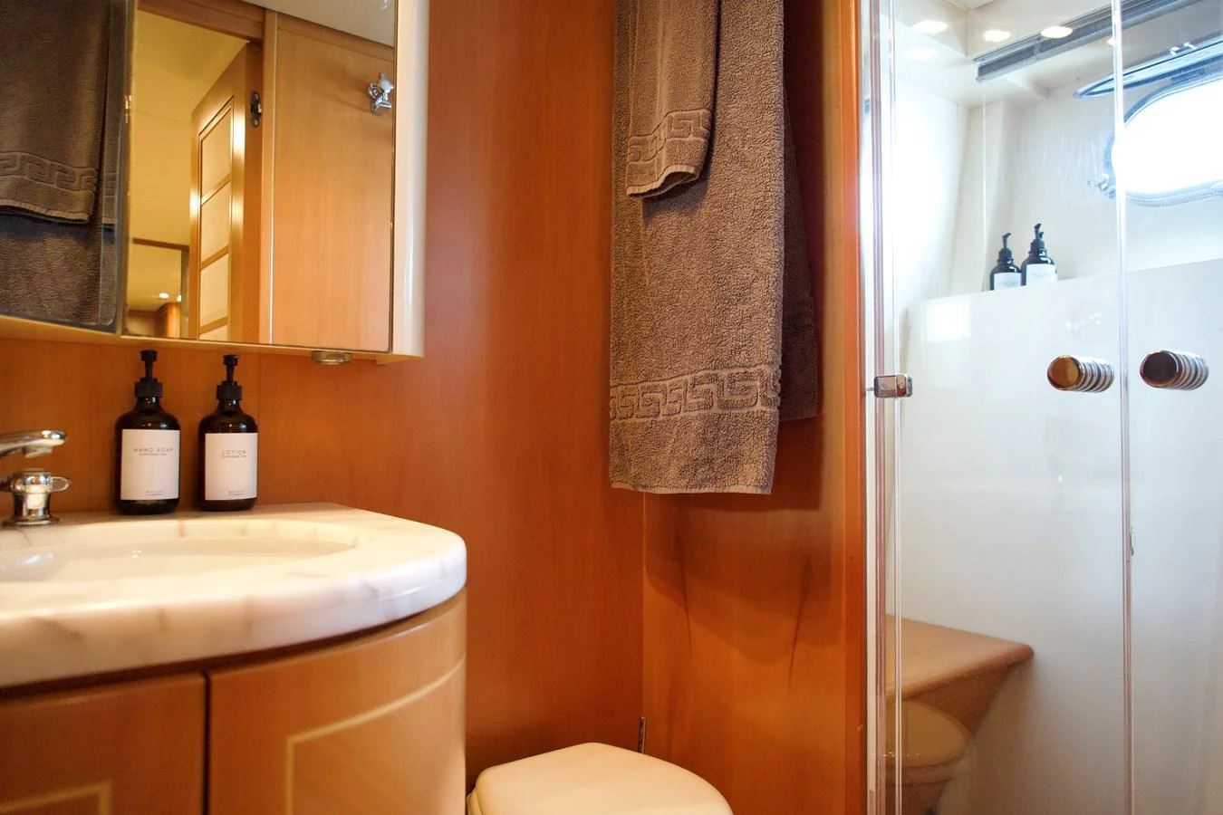 The yacht's bathroom features a sleek design with a marble countertop and a glass-enclosed shower. aboard CHEEKY TIGER Yacht for Sale