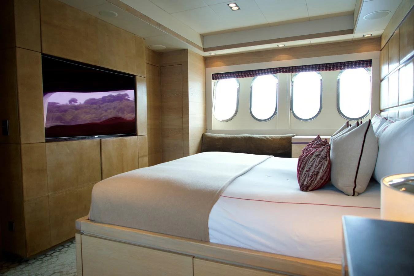 A luxurious stateroom featuring a large bed, ample natural light, and a flat-screen TV. aboard CHEEKY TIGER Yacht for Sale