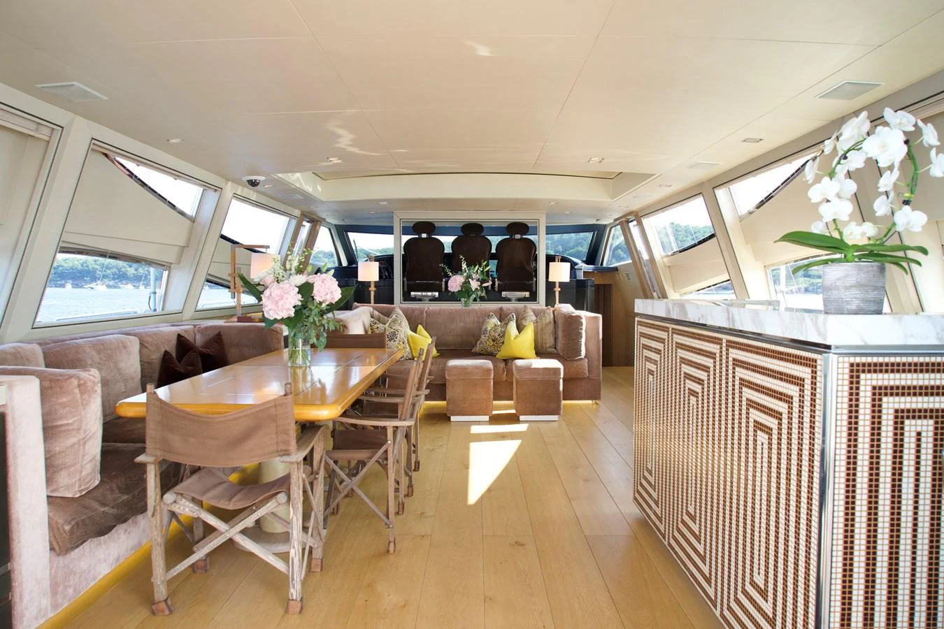 The salon features elegant seating, a dining area, and large windows for natural light. aboard CHEEKY TIGER Yacht for Sale