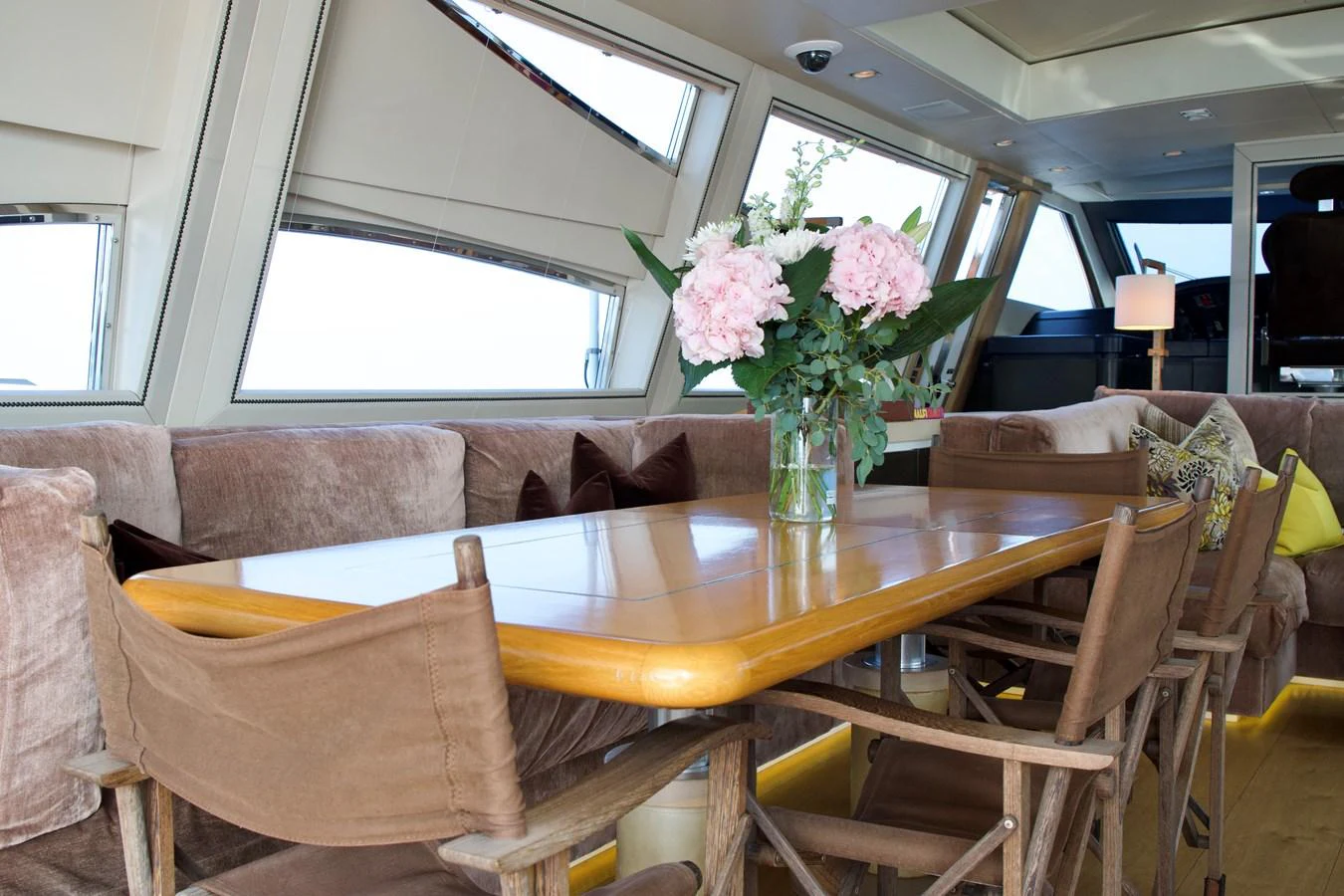The yacht's dining area features a wooden table with comfortable seating and elegant floral decor. aboard CHEEKY TIGER Yacht for Sale