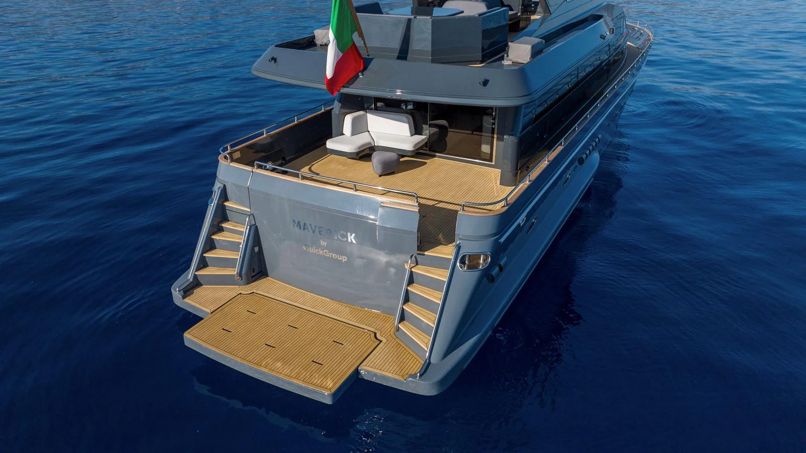 The yacht's aft deck features a spacious lounging area with elegant teak flooring, perfect for relaxation. aboard MAVERICK Yacht for Sale