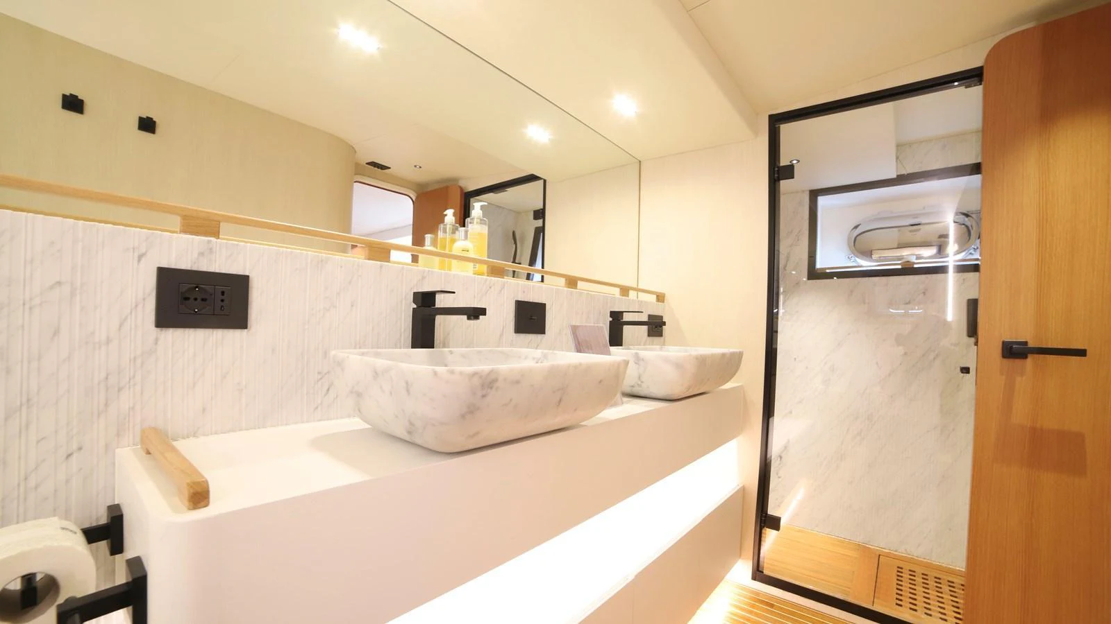 The yacht's bathroom features a modern design with dual sinks and a spacious shower area. aboard MAVERICK Yacht for Sale