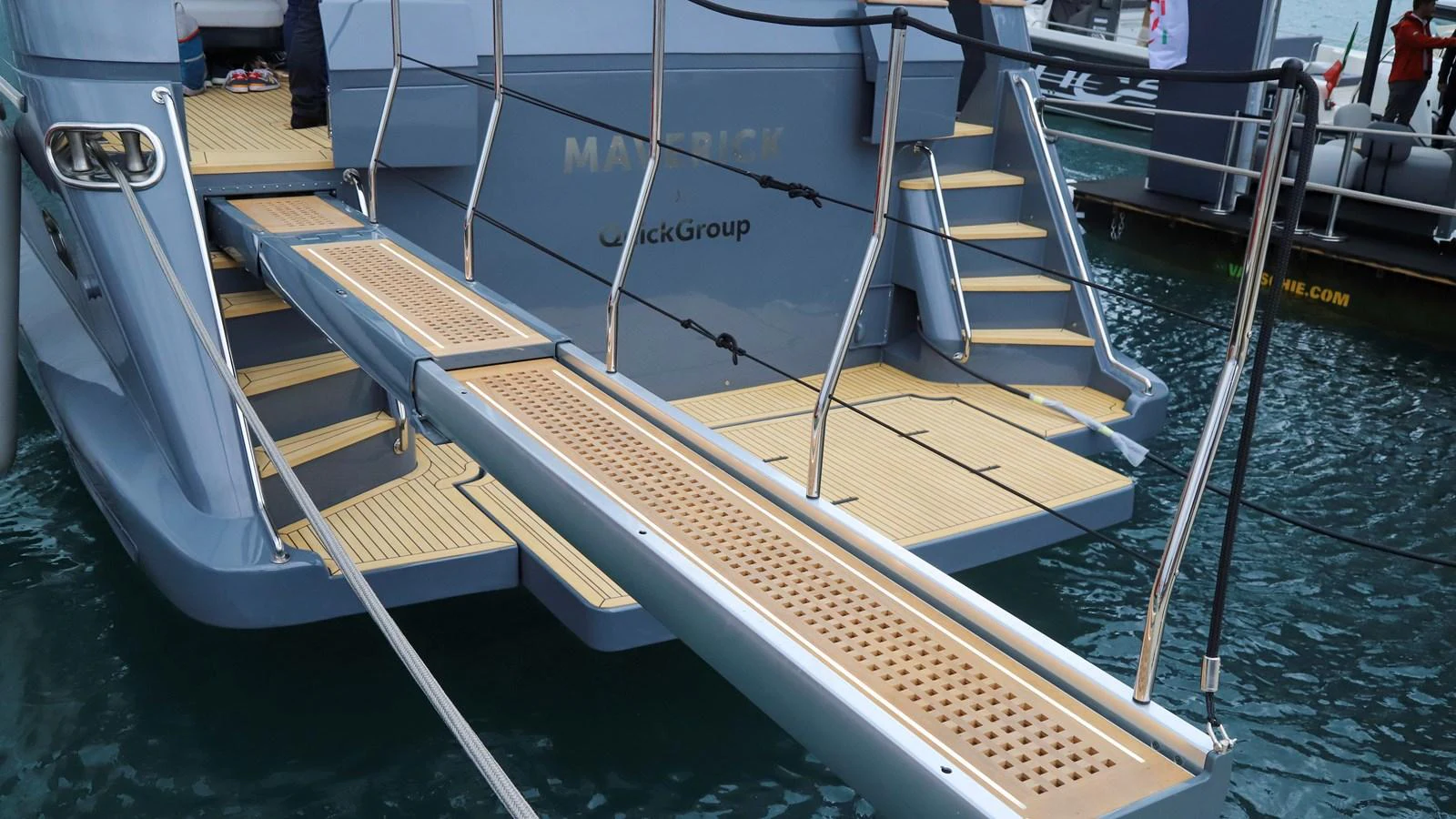 The image showcases a yacht's boarding platform extending over the water. aboard MAVERICK Yacht for Sale