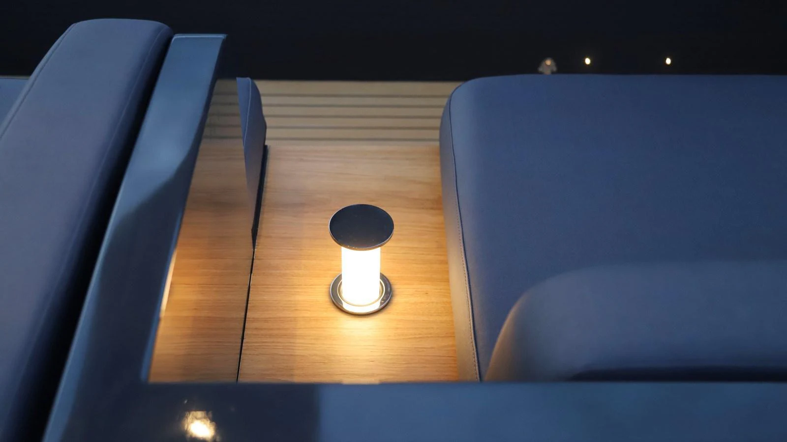 A close-up of a yacht's deck light illuminating a wooden surface next to cushioned seating. aboard MAVERICK Yacht for Sale